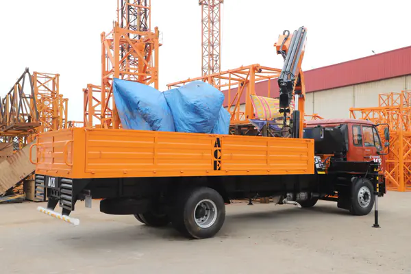 Autocarro con gru articolata e stabilizzatori in cantiere